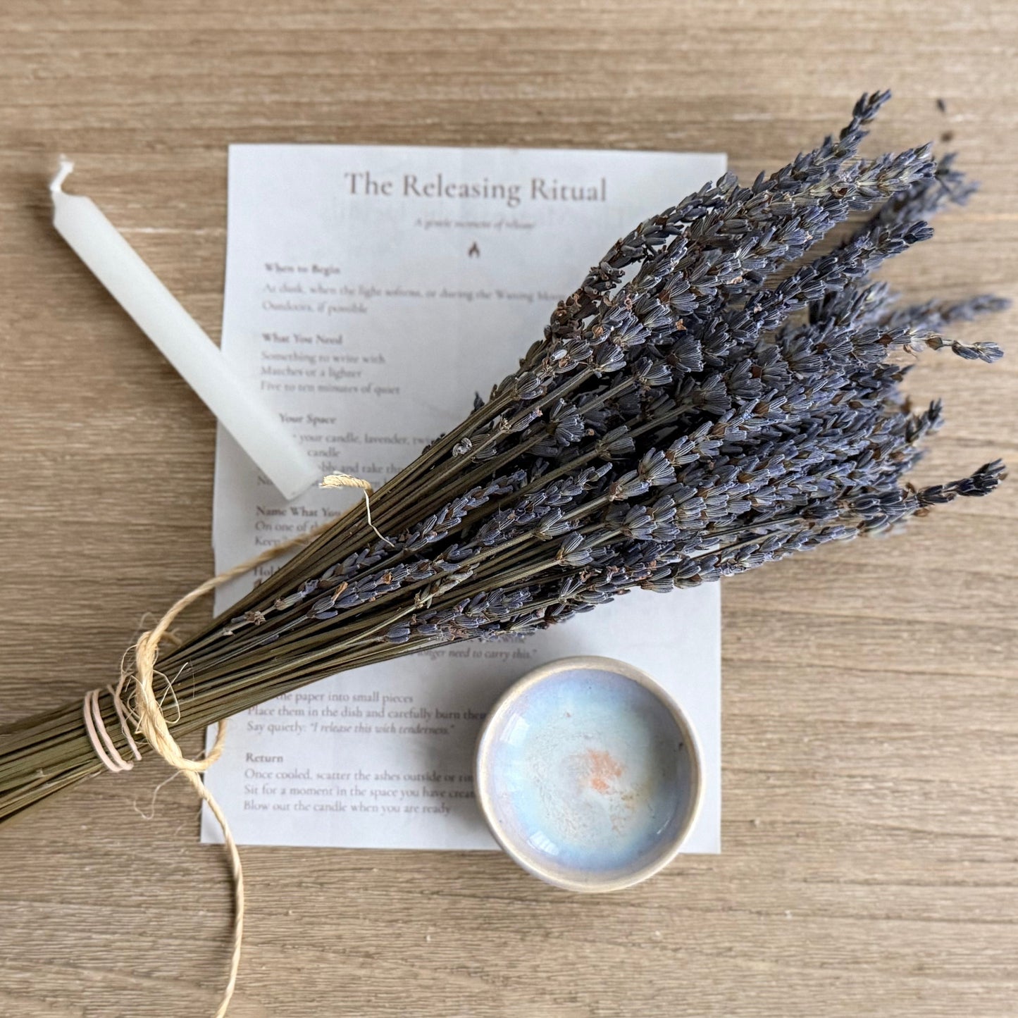 Bouquet of lavender on a wooden surface with a book and candle