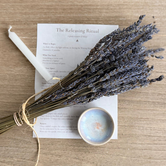 Bouquet of lavender on a wooden surface with a book and candle