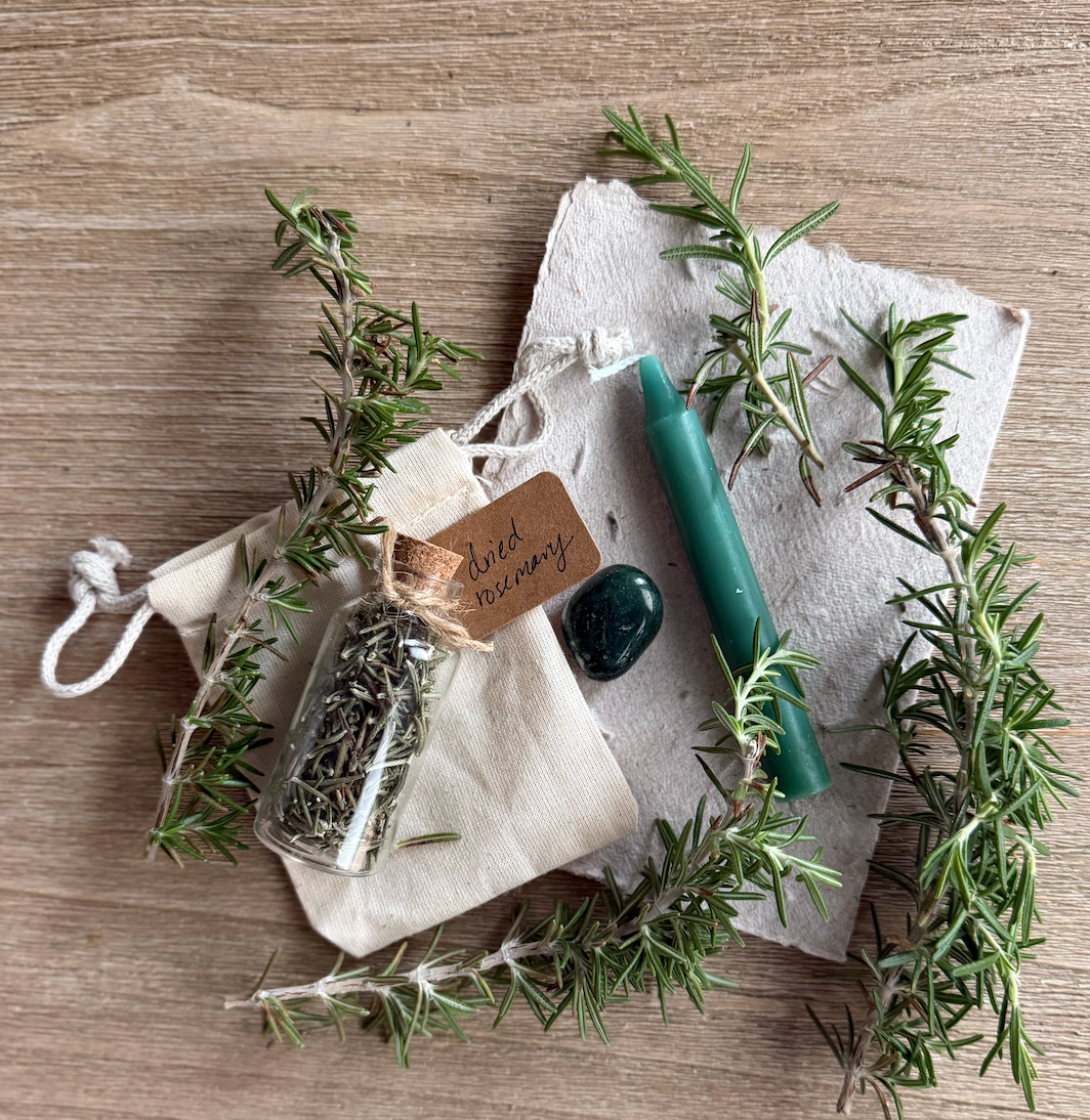 Herbs and a candle on a wooden surface with a rustic feel