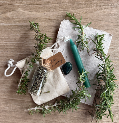 Herbs and a candle on a wooden surface with a rustic feel