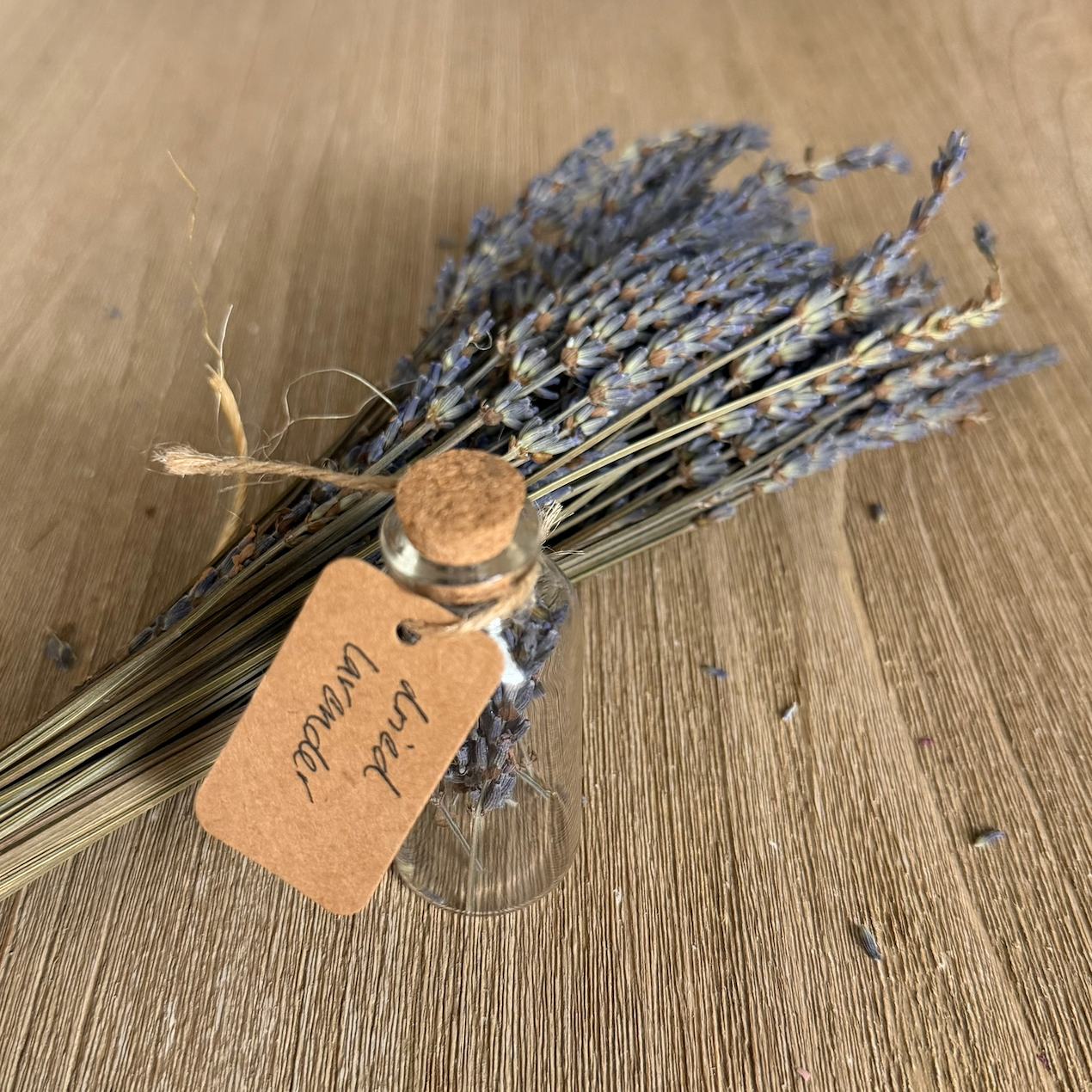 Glass jar with dried lavender and a tag on a wooden surface