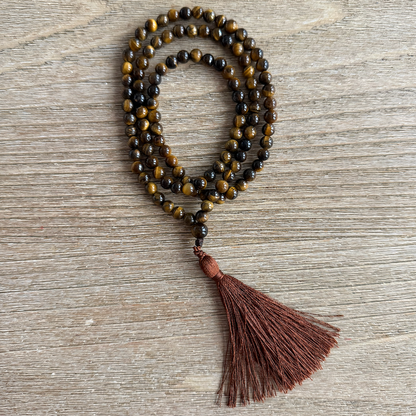 Beaded necklace with a tassel on a wooden surface